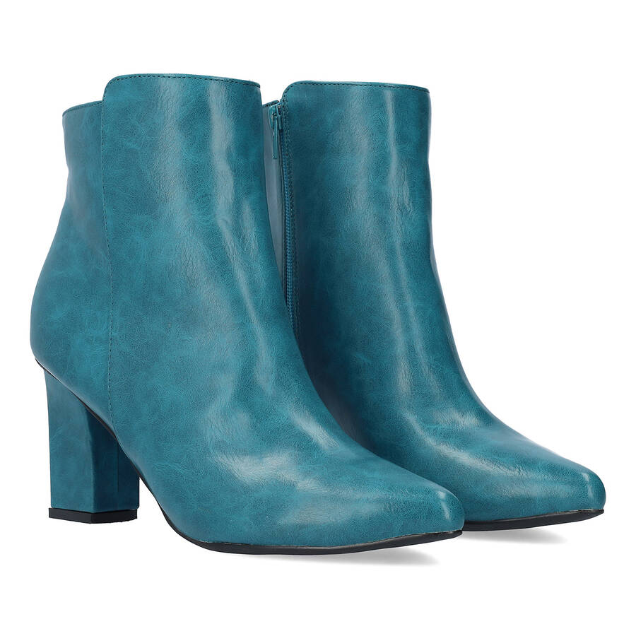 Heeled booties in blue faux leather. 