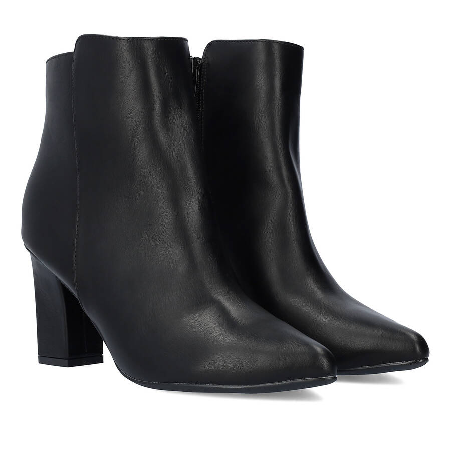 Heeled booties in black faux leather. 