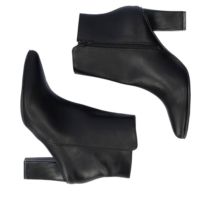 Heeled booties in black faux leather. 