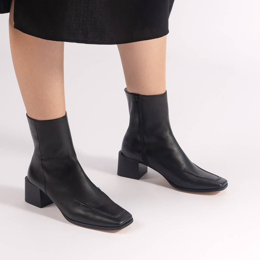 Heeled booties in black leather 